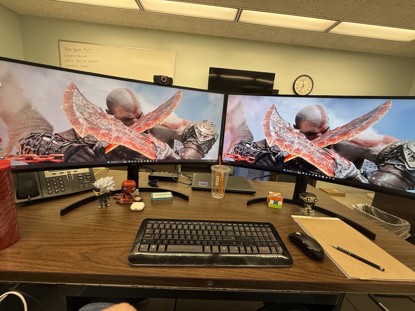 A wooden desk with two curved monitors and a keyboard