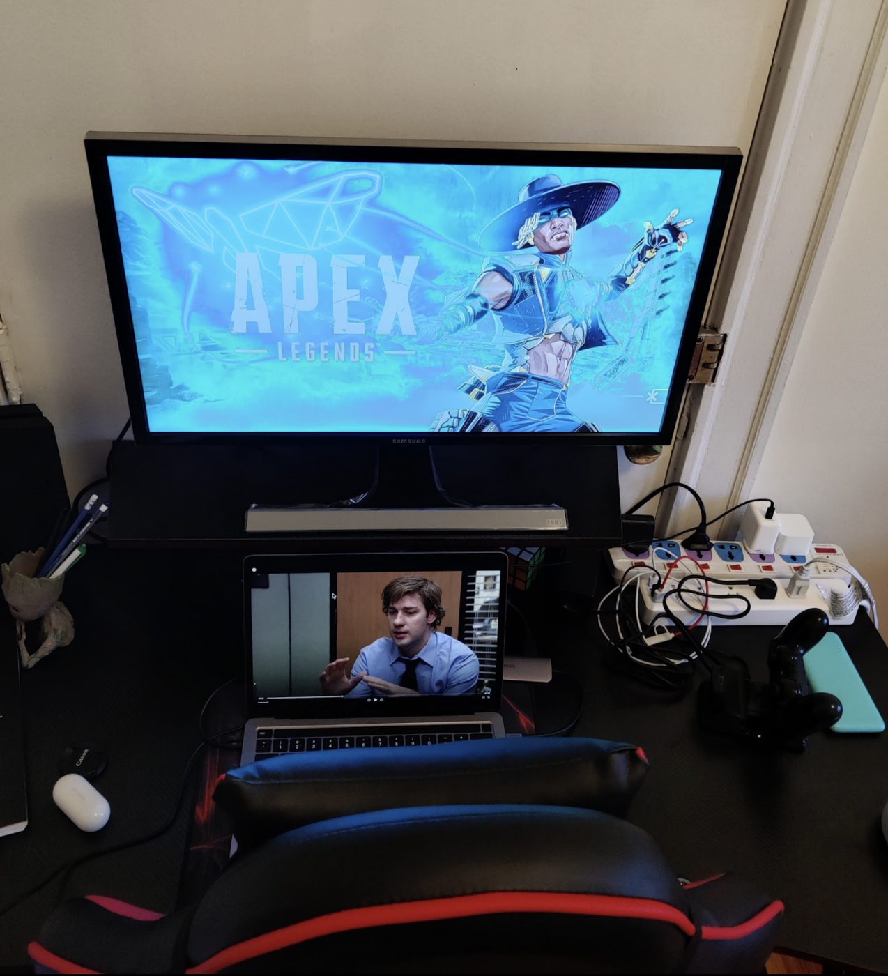 A large screen showing a game menu above a gaming chair