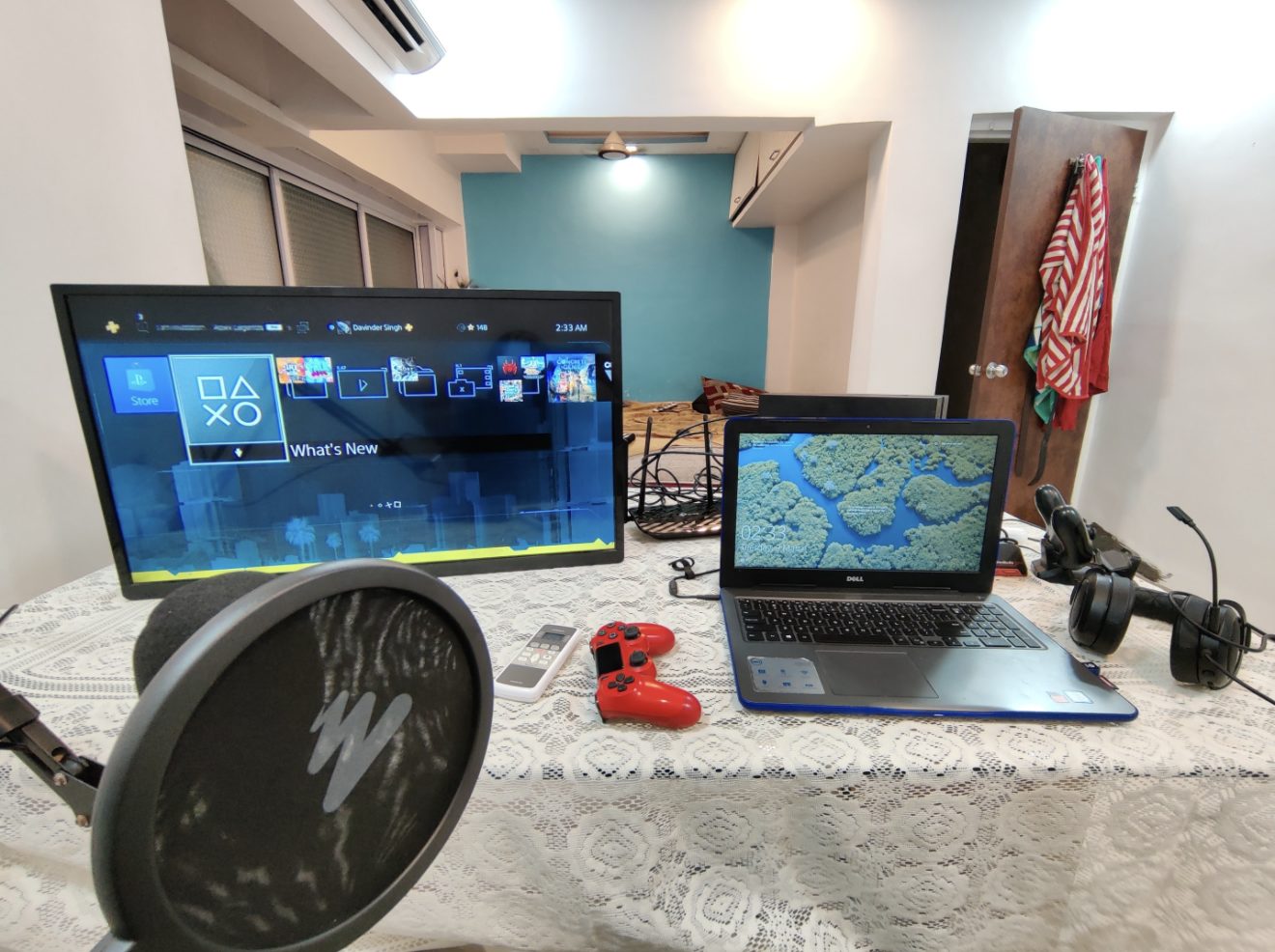 A laptop and a game controller on a patterned table