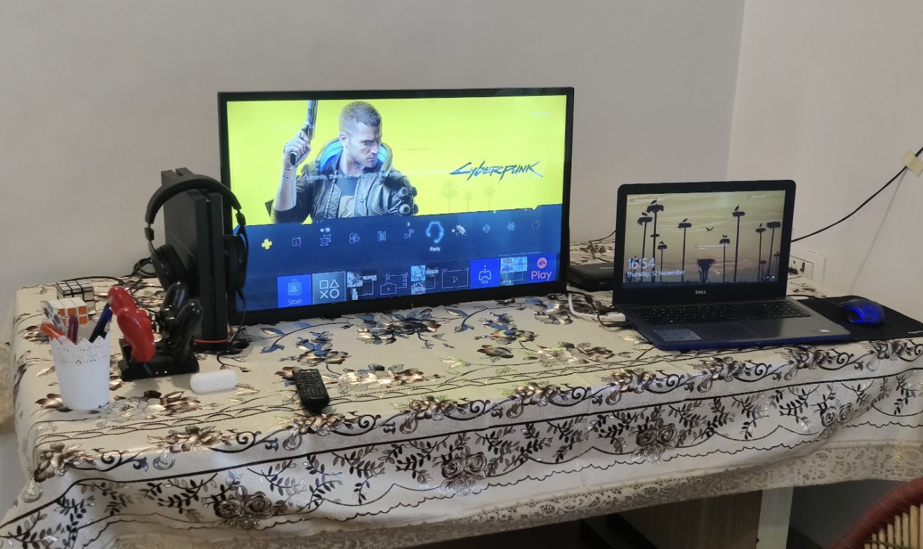 A monitor and laptop on a decorated table