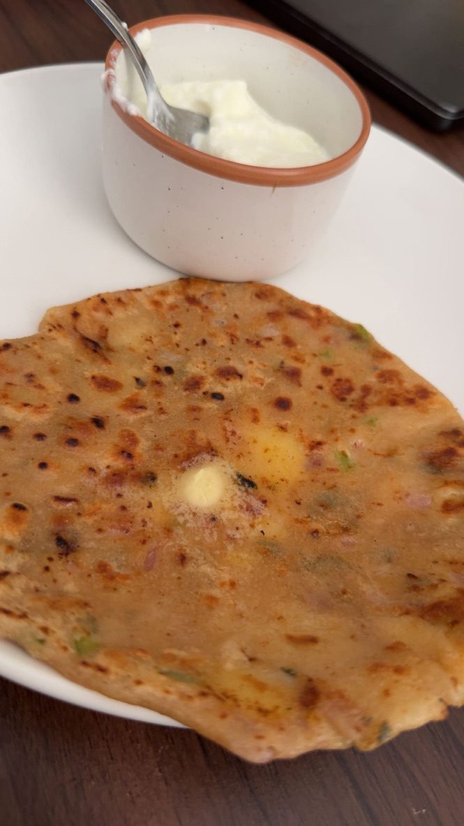 A stuffed flatbread with a bowl of yogurt