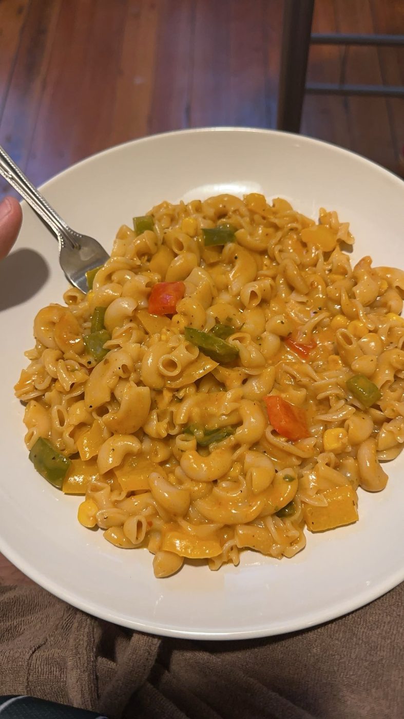 A bowl of creamy white-sauce pasta with bell peppers and corn, my favorite