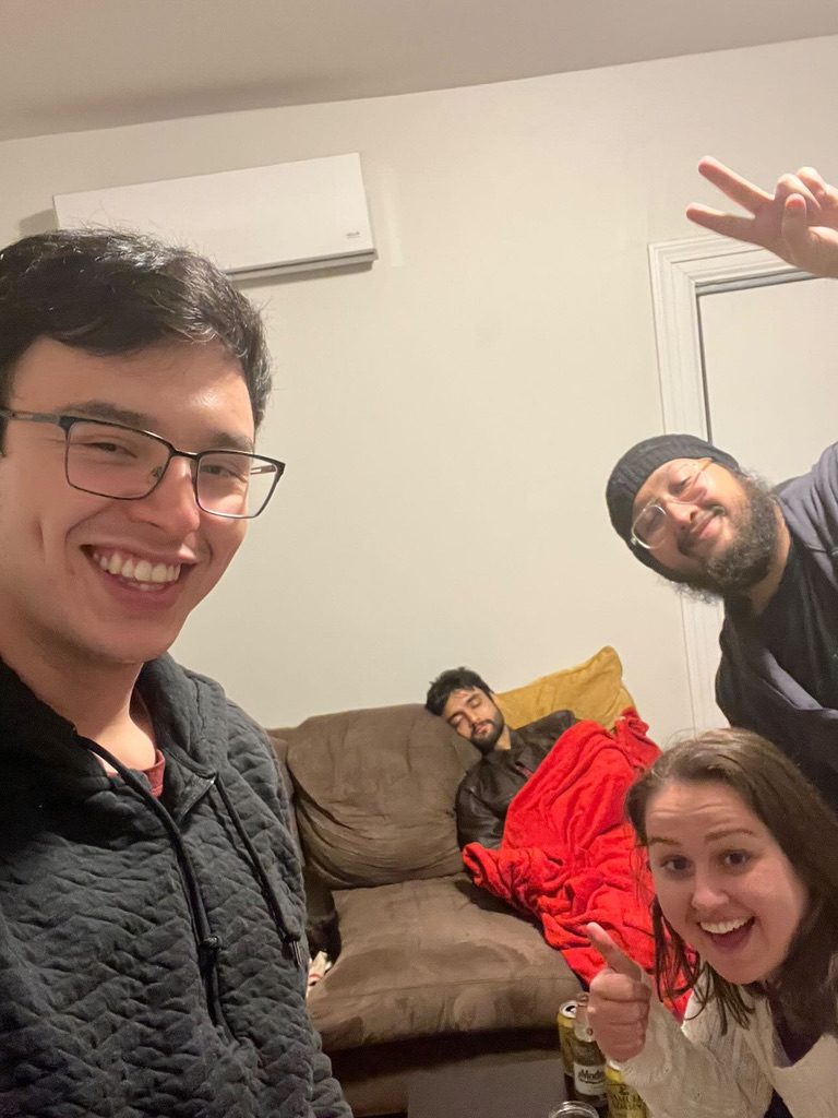 Dave with friends on a couch, smiling at the camera