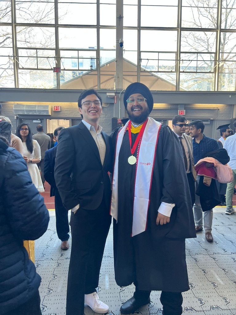 Dave in his graduation gown with friends in dress clothes