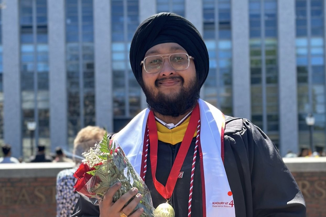 Dave in his graduation gown holding flowers